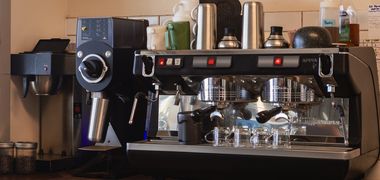 The shop's two-group espresso machine on the bar, with a grinder alongside